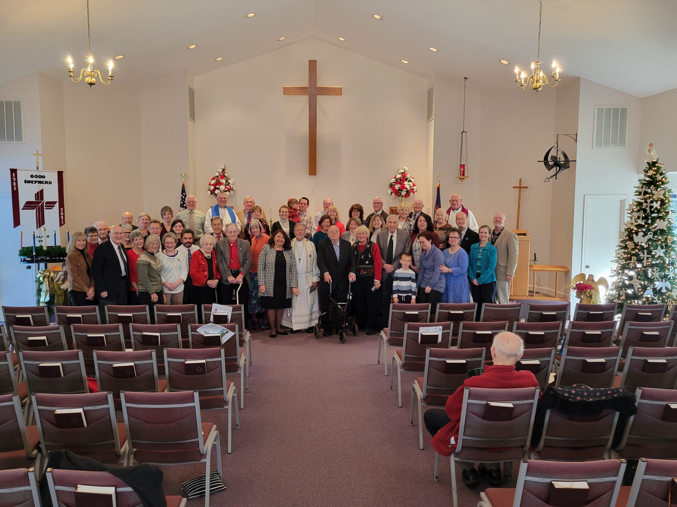 Photo of the Good Shepherd congregation standing for a group photo in front of the alter